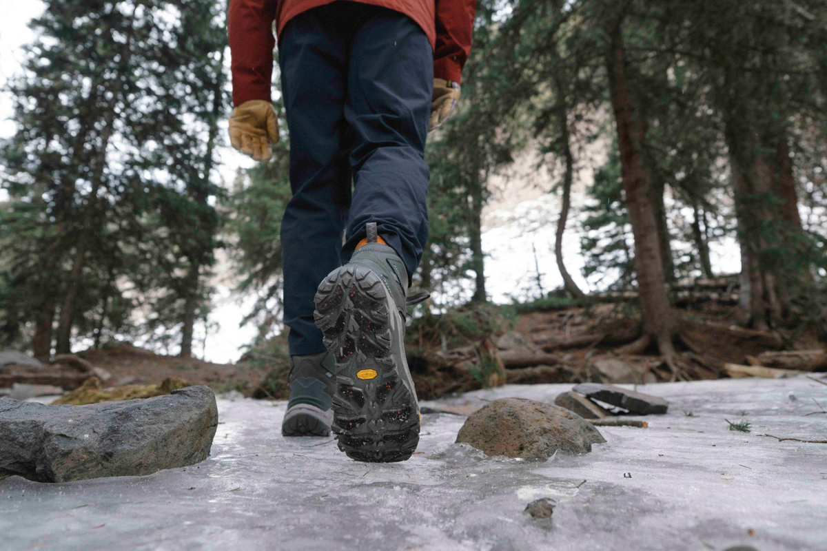 Person hiking on a forest trail wearing Charcoal gray Oboz Bangtail winter boots.