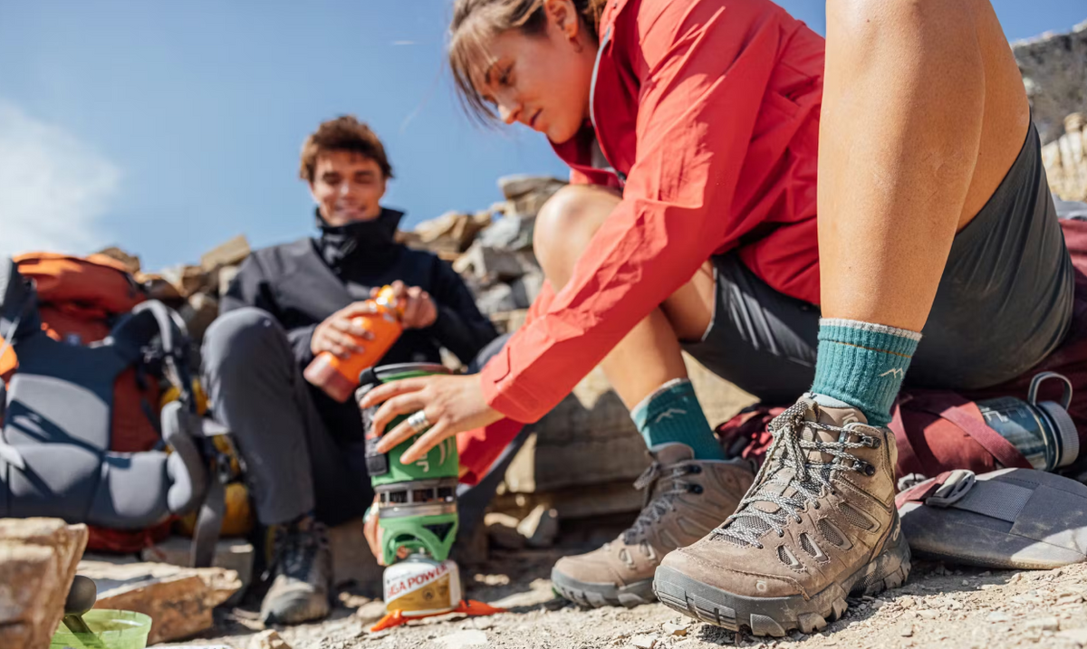 Two hikers in the Oboz Sawtooth X hiking shoe making food at camp. 