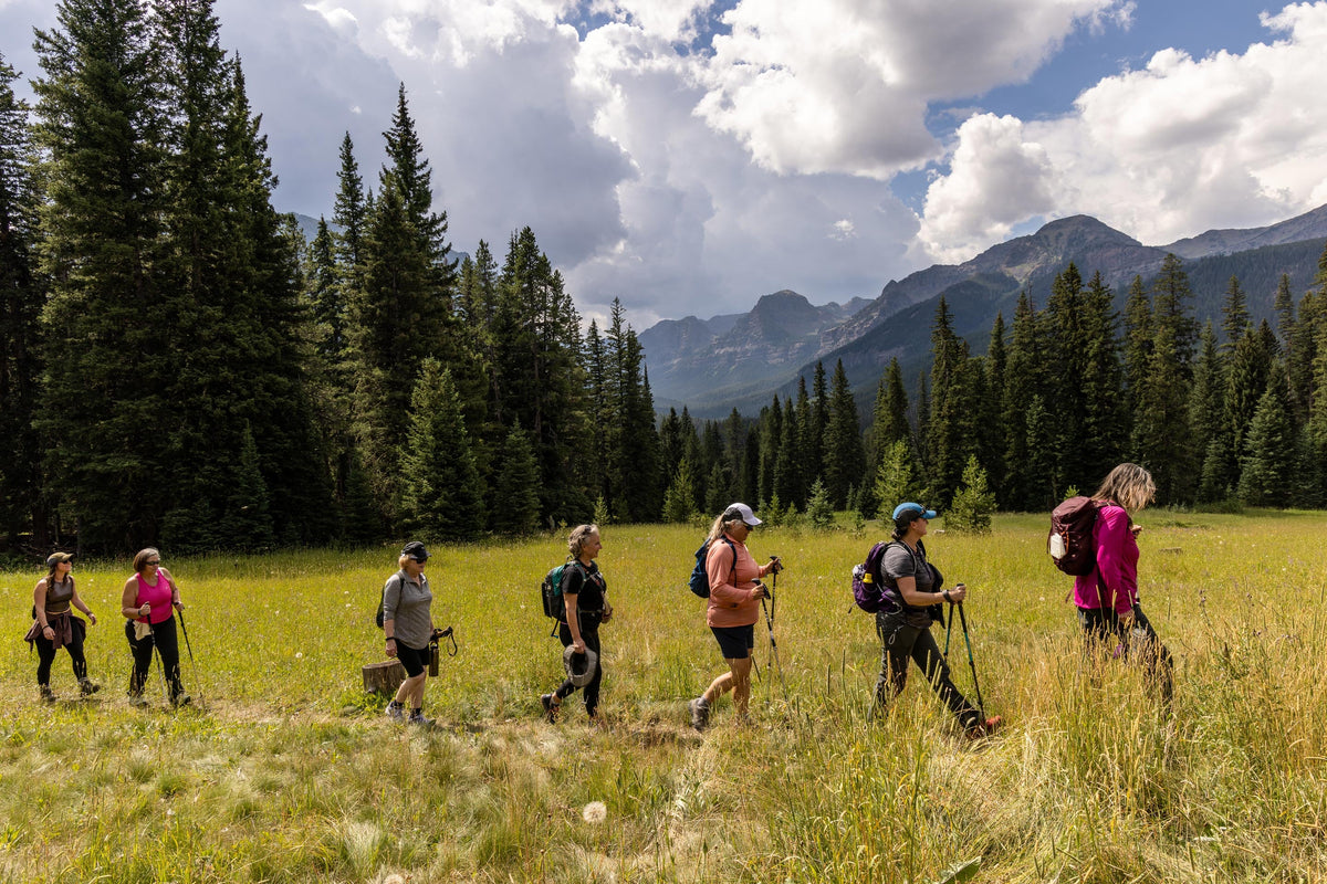 The women of the 52 Hike Challenge, hike through a meadow in Hyalite Canyon.