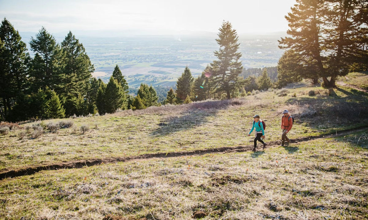 Two hikers on a trail wearing Oboz hiking shoes.