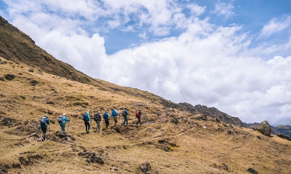 Hikers in Oboz footwear summit a long trail in Peru. 