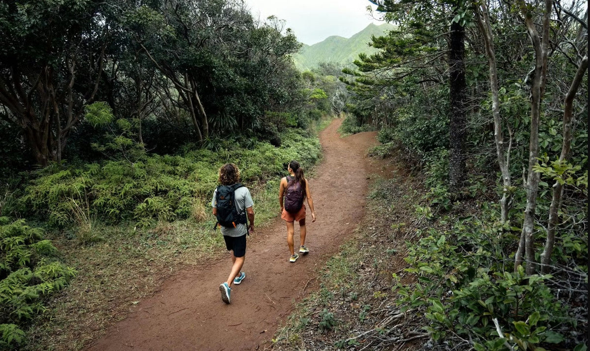 Two people walk through a hiking trail in Hawaii in Oboz Cottonwood hiking shoes. 