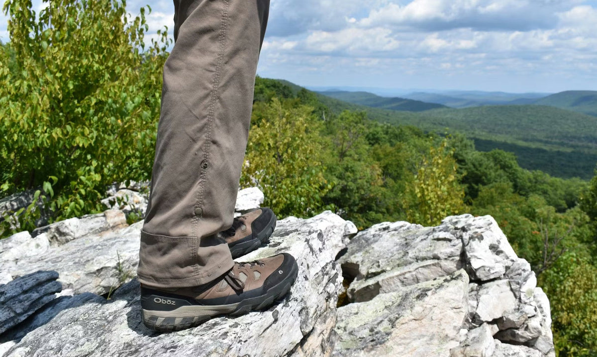 Hiker on rocky overlook wearing Oboz Sawtooth X hiking boots.