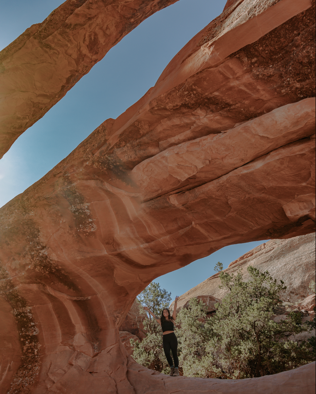 Lindsay Kagalis under an arch on Núu-agha-tʉvʉ-pʉ̱ (Ute) Indigenous lands