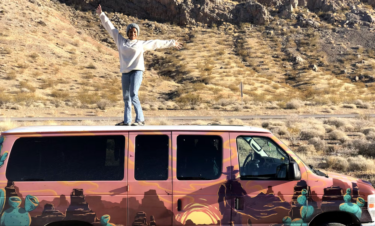 Woman standing on a van in desert