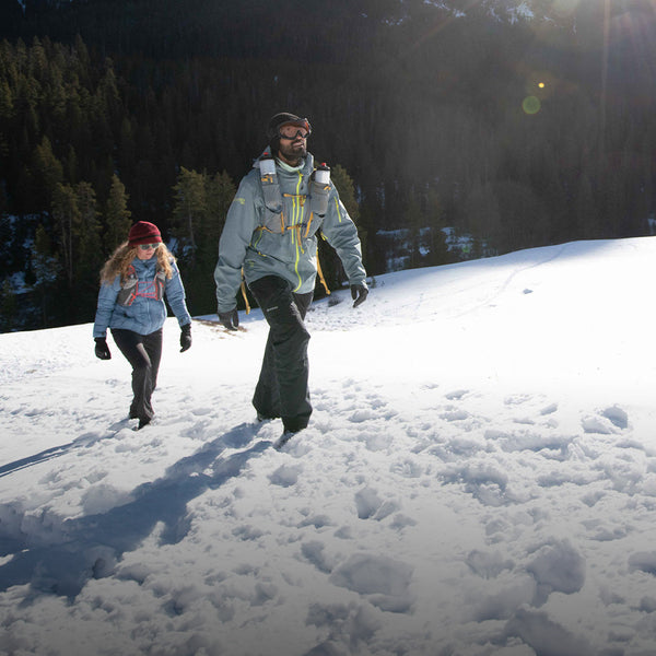 Hiker treks across icy trail in Oboz snow boots.