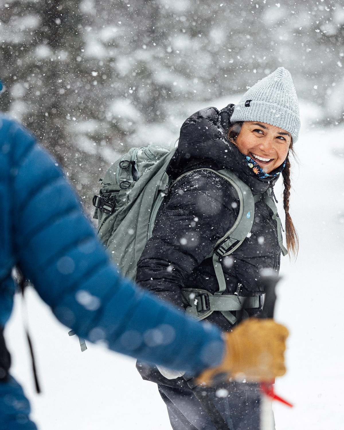 Person hiking in the snow with a backpack, wearing Oboz Bridger Insulated winter hiking boots