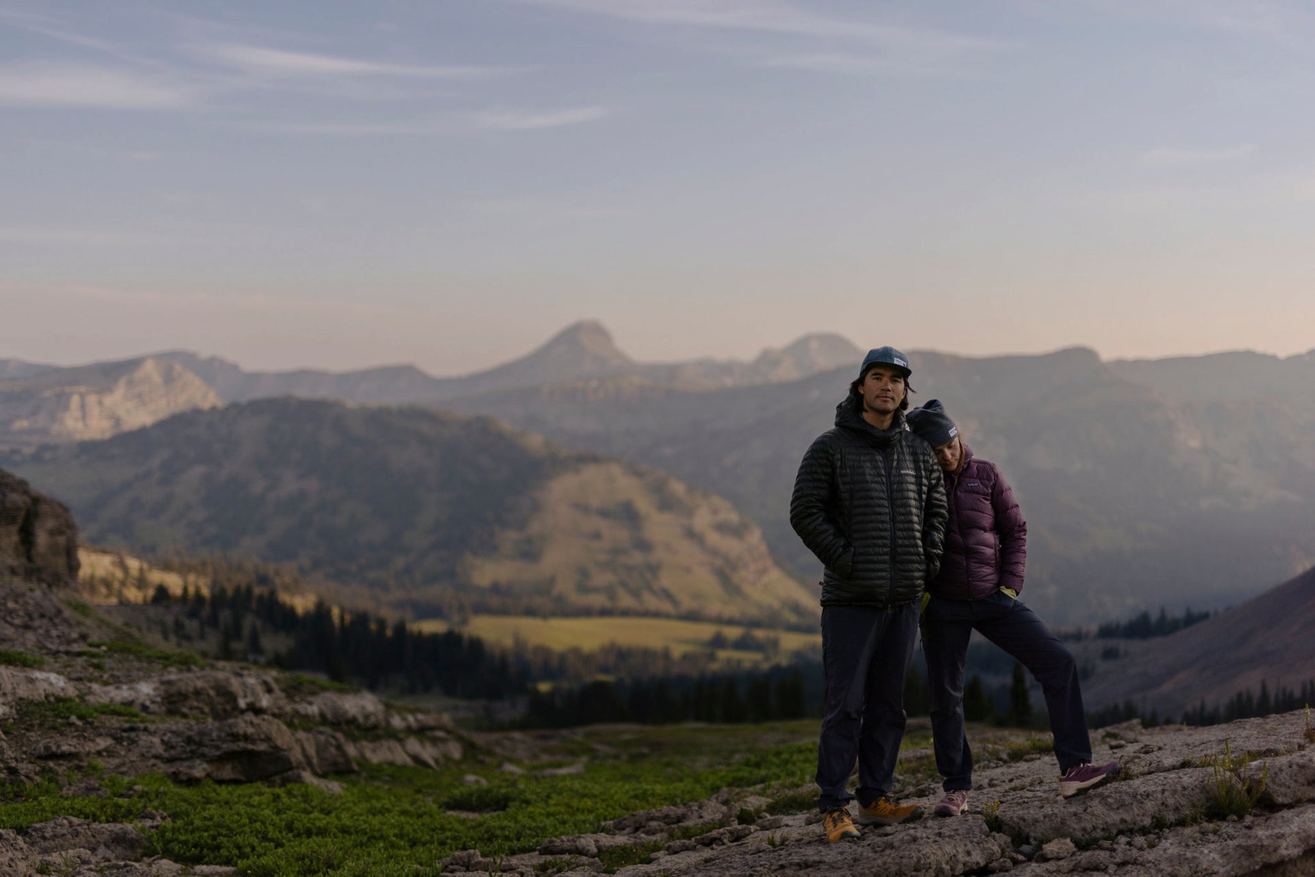 Two people standing on a mountain with scenic landscape in the background, wearing Oboz Katabatic RT hiking shoes