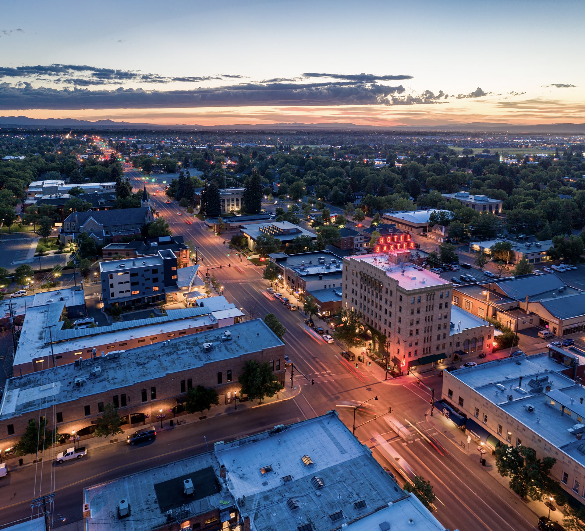 Aerial view of Bozeman streets at dusk with illuminated buildings and roads.
