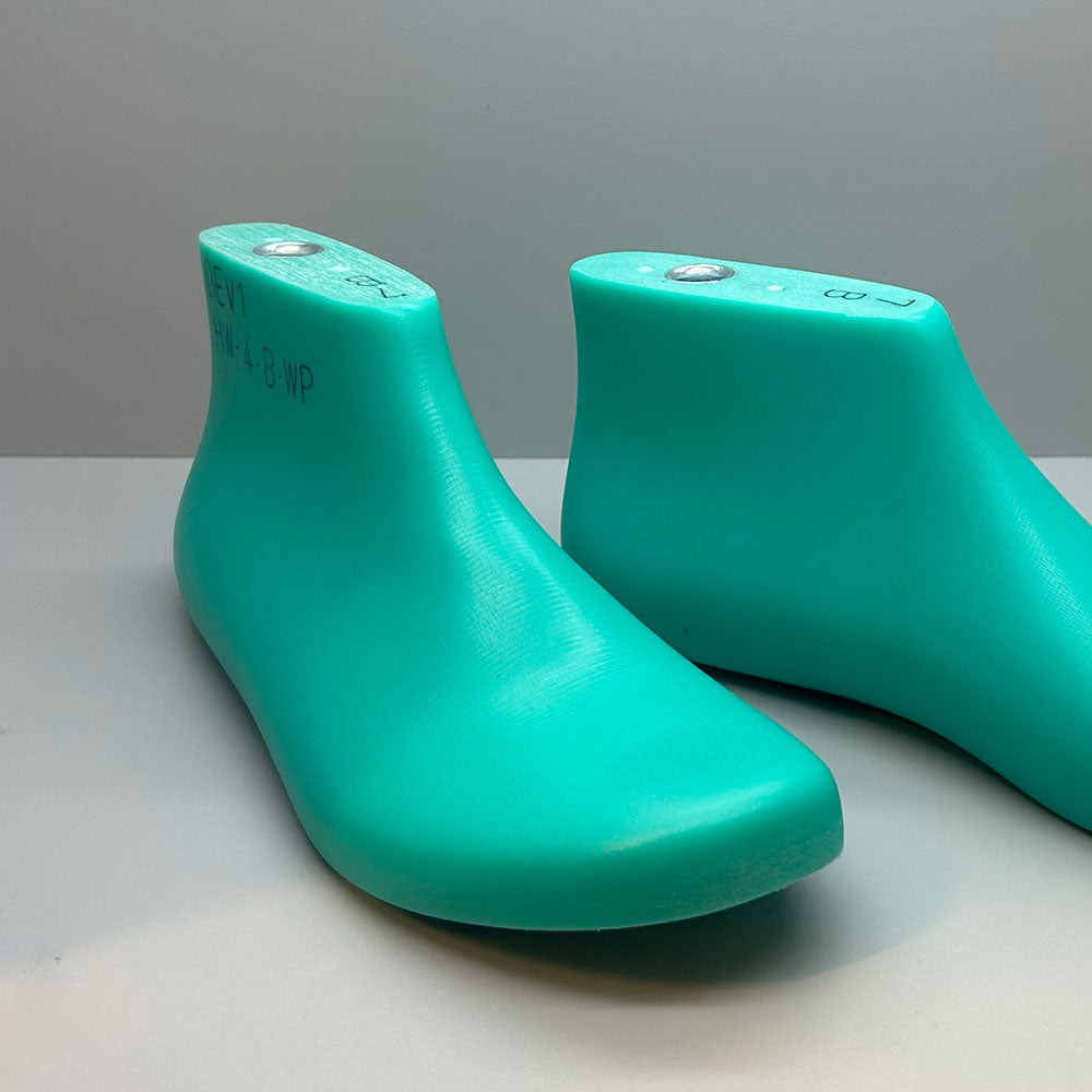 Pair of shoe lasts on a gray background