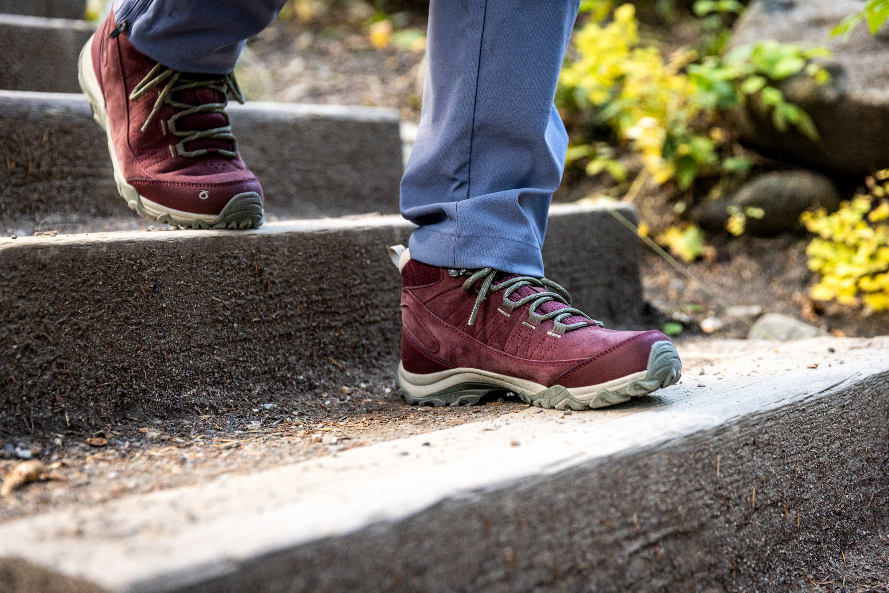 Person wearing Port red Oboz Ousel Mid hiking boots climbing stone steps with a natural background