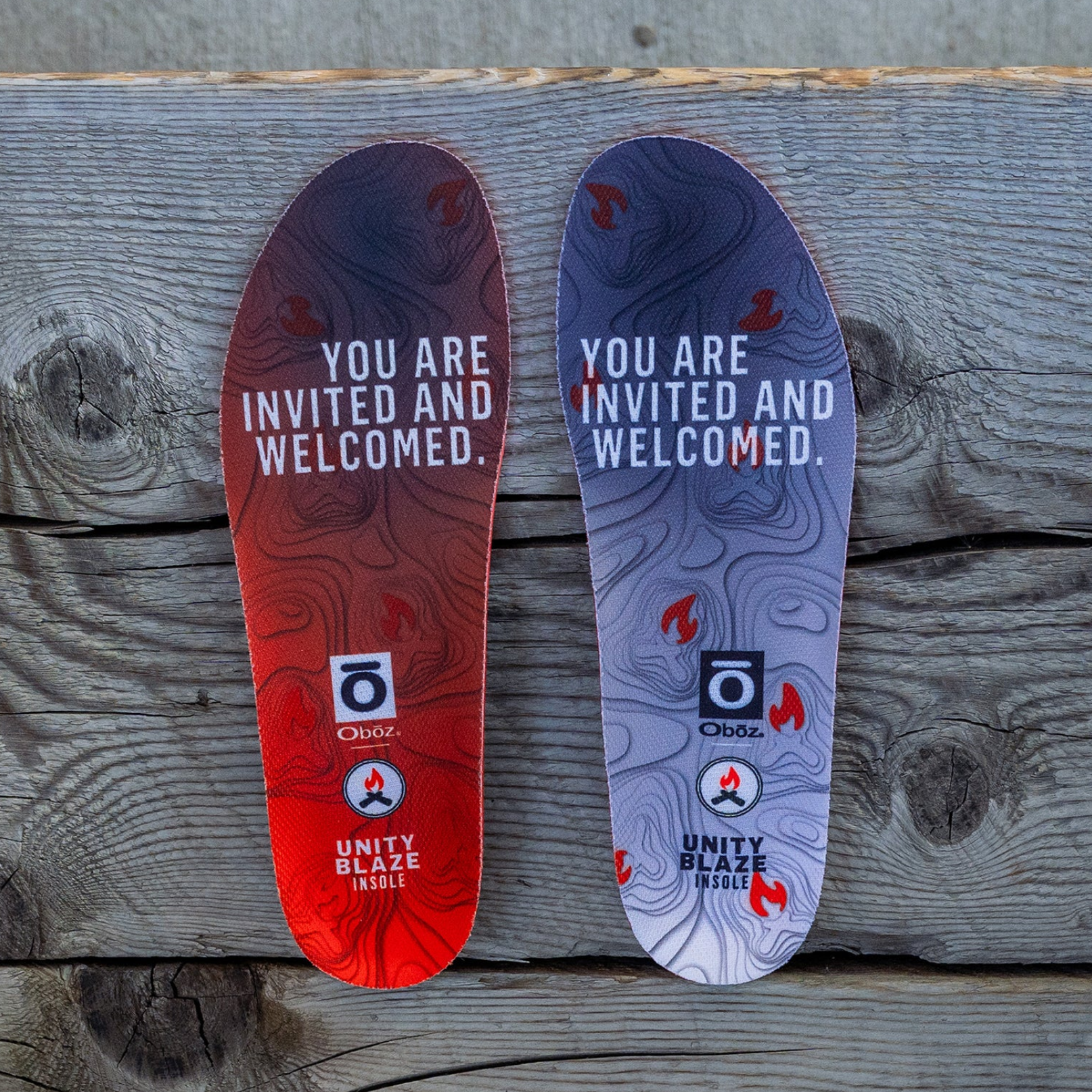 Two Oboz Trail shoe insoles with text and branding on a wooden surface