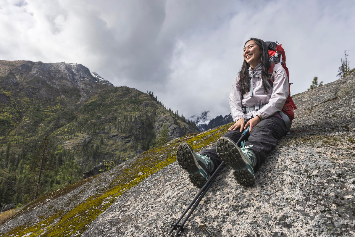 Person sitting on a rock with backpacking gear wearing Oboz Bridger Ridge hiking boots