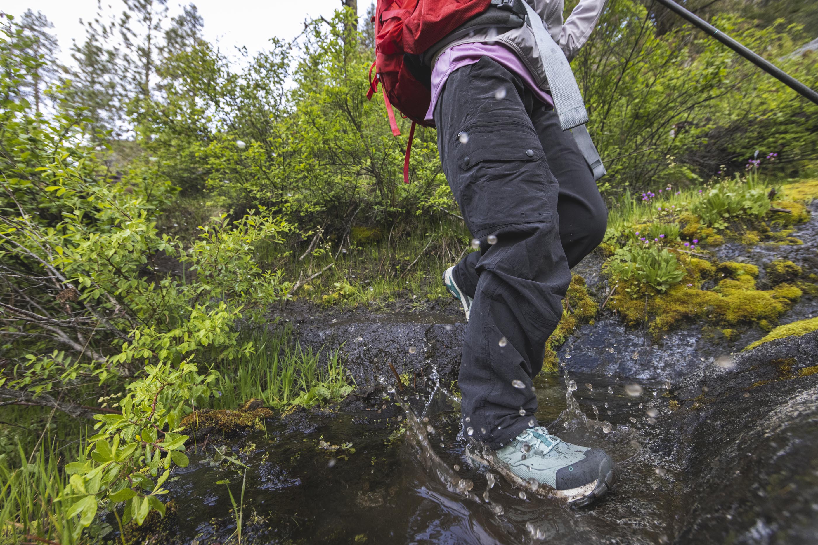 Person hiking through a creek wearing Oboz Bridger Ridge hiking boots.